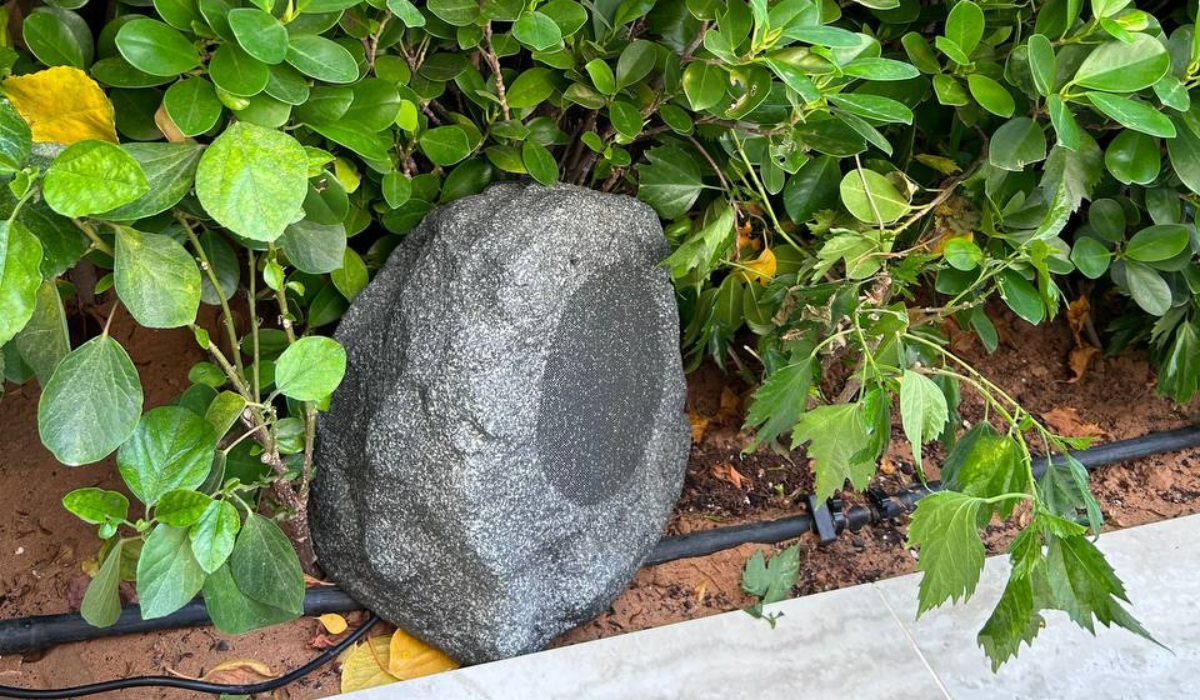 Artsound ROCKS faux-stone outdoor speaker tucked into garden landscaping